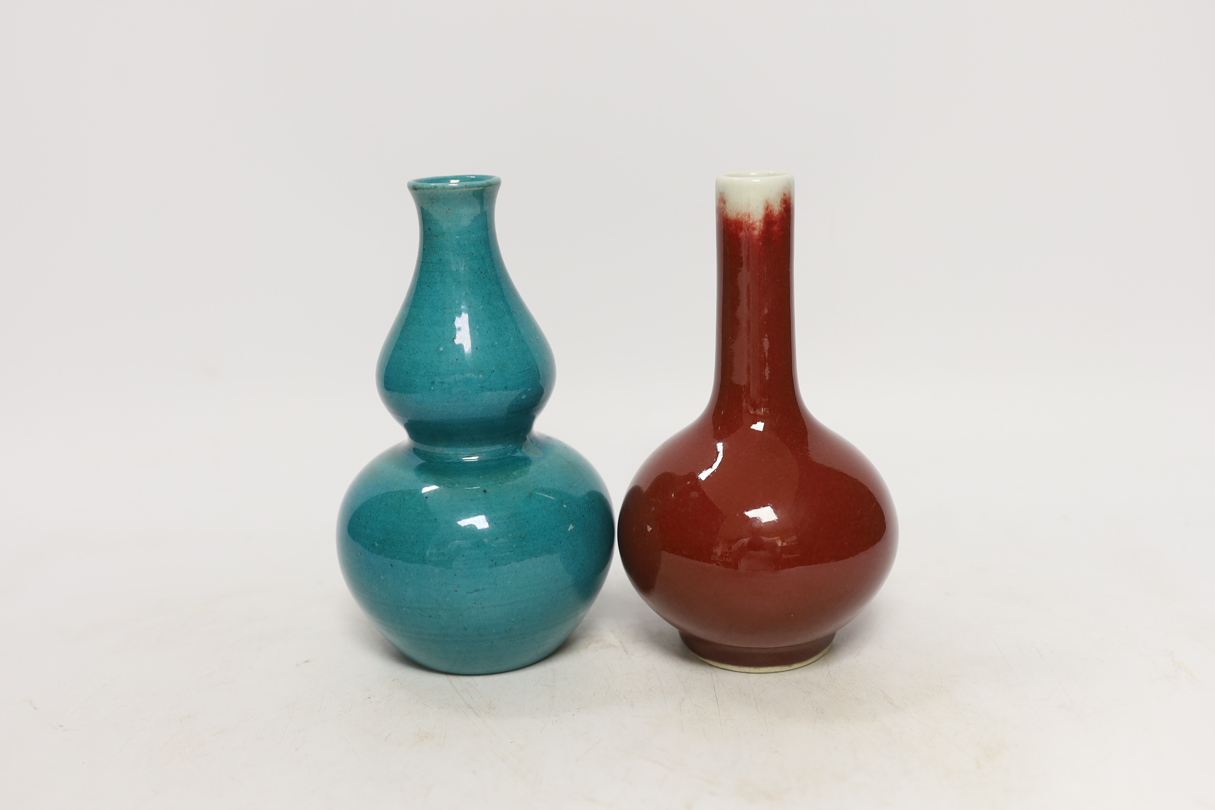 A Chinese monochrome gourd vase together with a similar sang de boeuf bottle vase, tallest 16cm